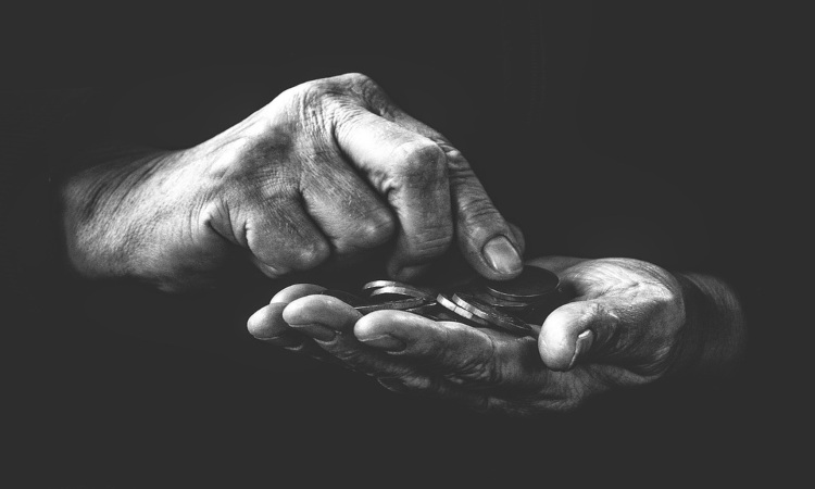 Due mani di un uomo con dei soldi (Pixabay)