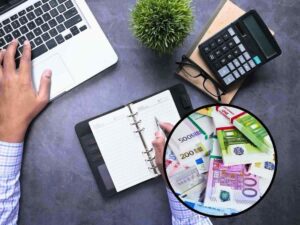 sfondo lavoratore alla scrivani e pc e tondo con banconote euro