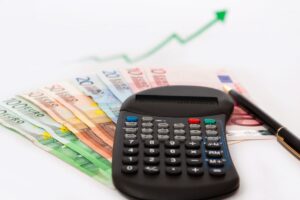 Calcolatrice, banconote e freccia verso l'alto
