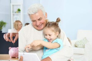 Nonno che gioca con nipote e savadanaio