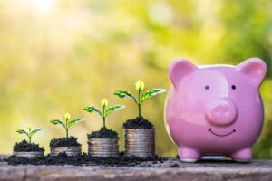 Monete che crescono come piantine e salvadanaio