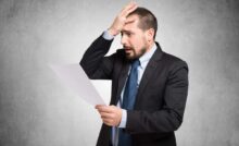 Persona che si dispera mentre legge un documento