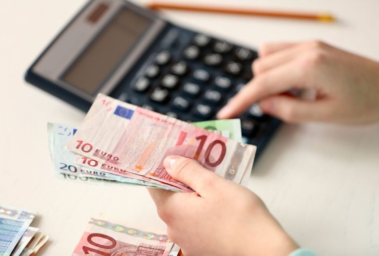 Persona che fa calcoli e conta delle banconote