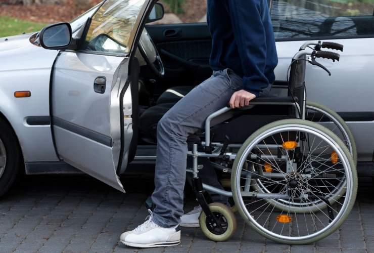 Disabile con sedia a rotele che sale in auto