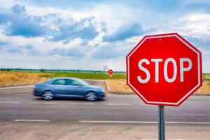 Auto che corre e segnale di Stop