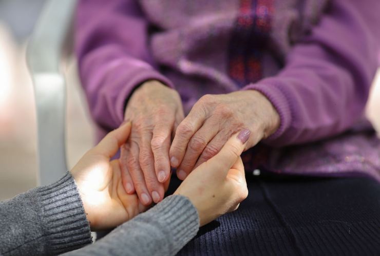 Caregiver che tiene per mano un disabile