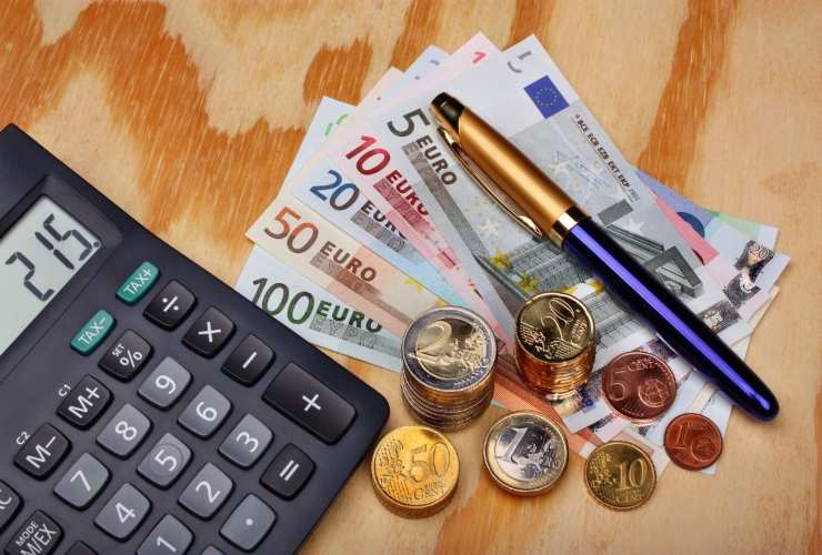Banconote, monete, calcolatrice e penna