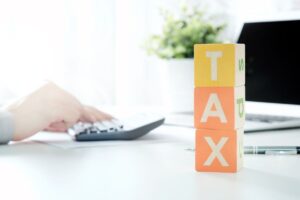 Persona che fa calcoli e scritta Tax