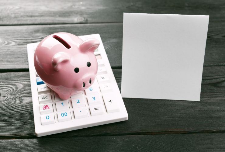 Calcolatrice, salvadanaio e block notes